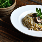 Mushroom Risotto Presentation**

"A beautifully plated mushroom risotto, garnished with fresh thyme sprigs, served on a rustic wooden table in a brightly lit kitchen. The risotto is creamy and perfectly cooked, with visible mushroom pieces. Focus on textures and appetizing presentation. fully clothed, appropriate content, safe for work, professional, perfect anatomy, natural proportions, high quality."

**